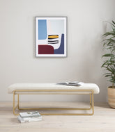 Modern living room with a bench, books, and abstract art on the wall.