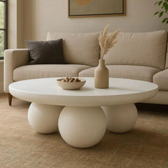 Modern living room with a round coffee table, beige sofa, and decorative elements.