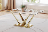 Glass dining table with gold metal legs in a room with light wood flooring and curtains.