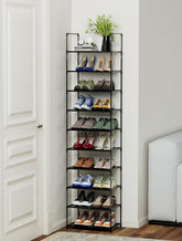 Tall black shoe rack with various shoes on a white wall background
