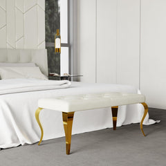 White upholstered bench with gold legs in a bedroom setting