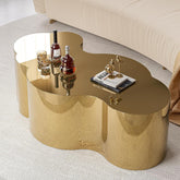 Gold coffee table with decorative items on a light-colored floor.