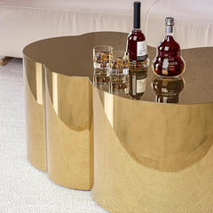 Gold side table with bottles and glasses on a white carpeted floor.