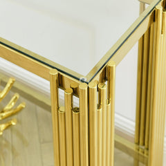 Gold cylindrical console table with glass top against a white wall