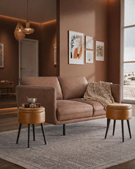 Modern living room with brown sofa, round side tables, and wall art.