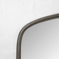 Decorative mirror with a textured frame on a white background