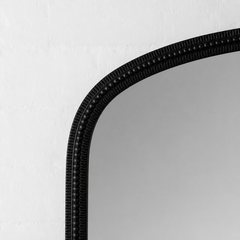 Black-framed mirror on a white wall