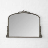 Decorative mirror with ornate frame on a white background
