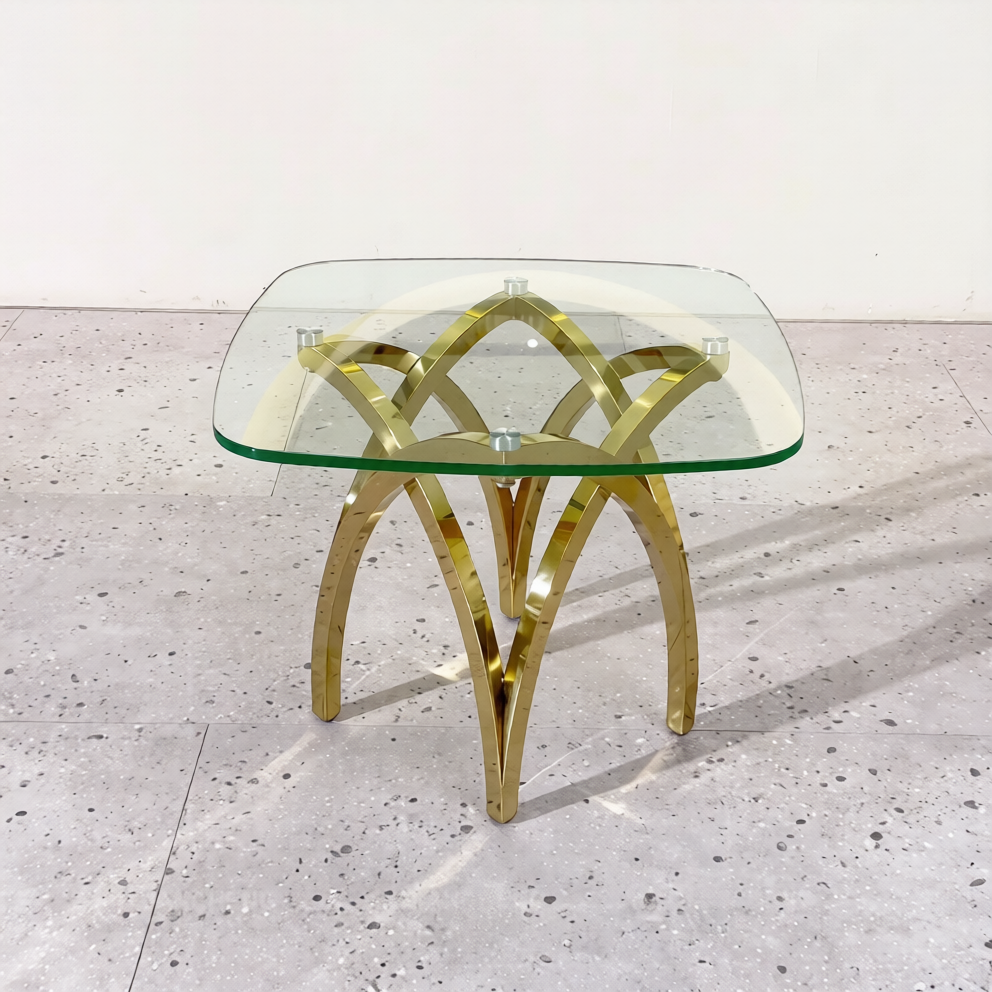Glass table with gold metal legs on a light gray floor