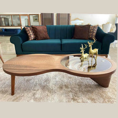 Teal sofa with decorative pillows and a wooden coffee table with decorative items in a living room setting.