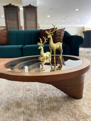 Gold deer figurines on a glass coffee table in a living room setting.