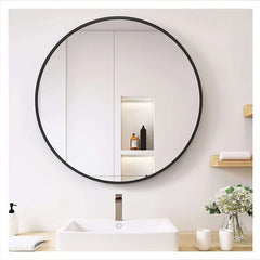 Round mirror with black frame in a bathroom setting