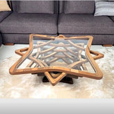 Wooden star-shaped coffee table in a living room setting with a gray sofa.