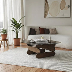 Modern living room with a coffee table, plants, and a sofa.