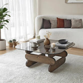 Modern living room with a glass coffee table, white sofa, and decorative items.