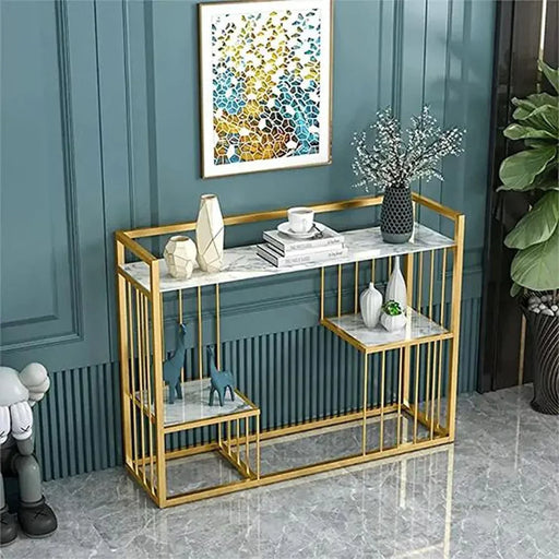 Gold console table with marble top against a teal wall with a decorative painting.