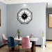 Modern dining room with a decorative wall clock on a gray wall.