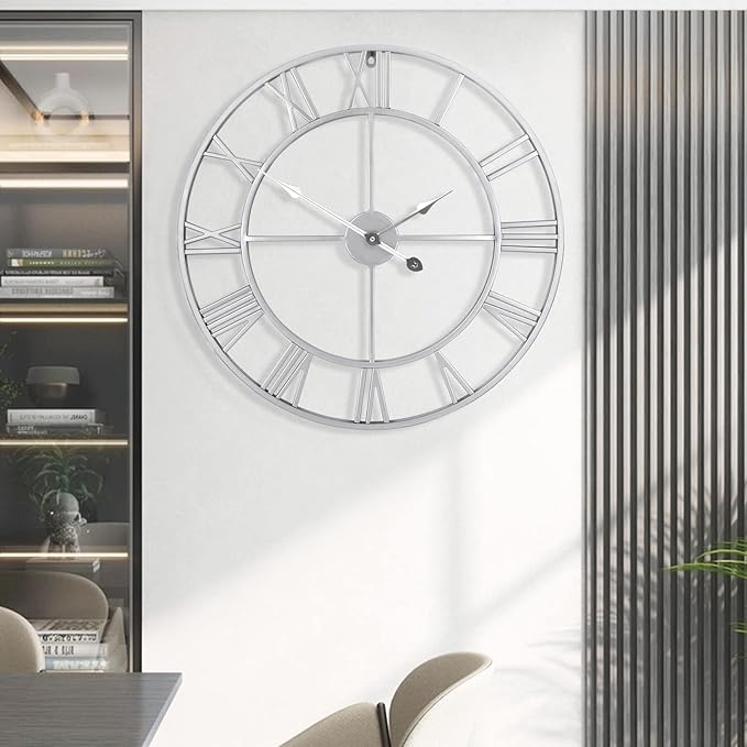 Large silver wall clock on a white wall with a modern interior setting.