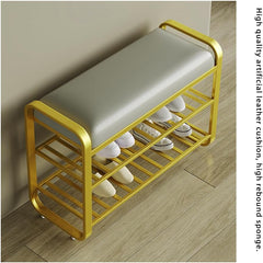 Shoe rack with a cushioned seat on a wooden floor, holding white shoes.