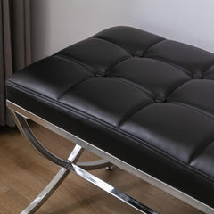 Black leather bench with chrome frame on a wooden floor.