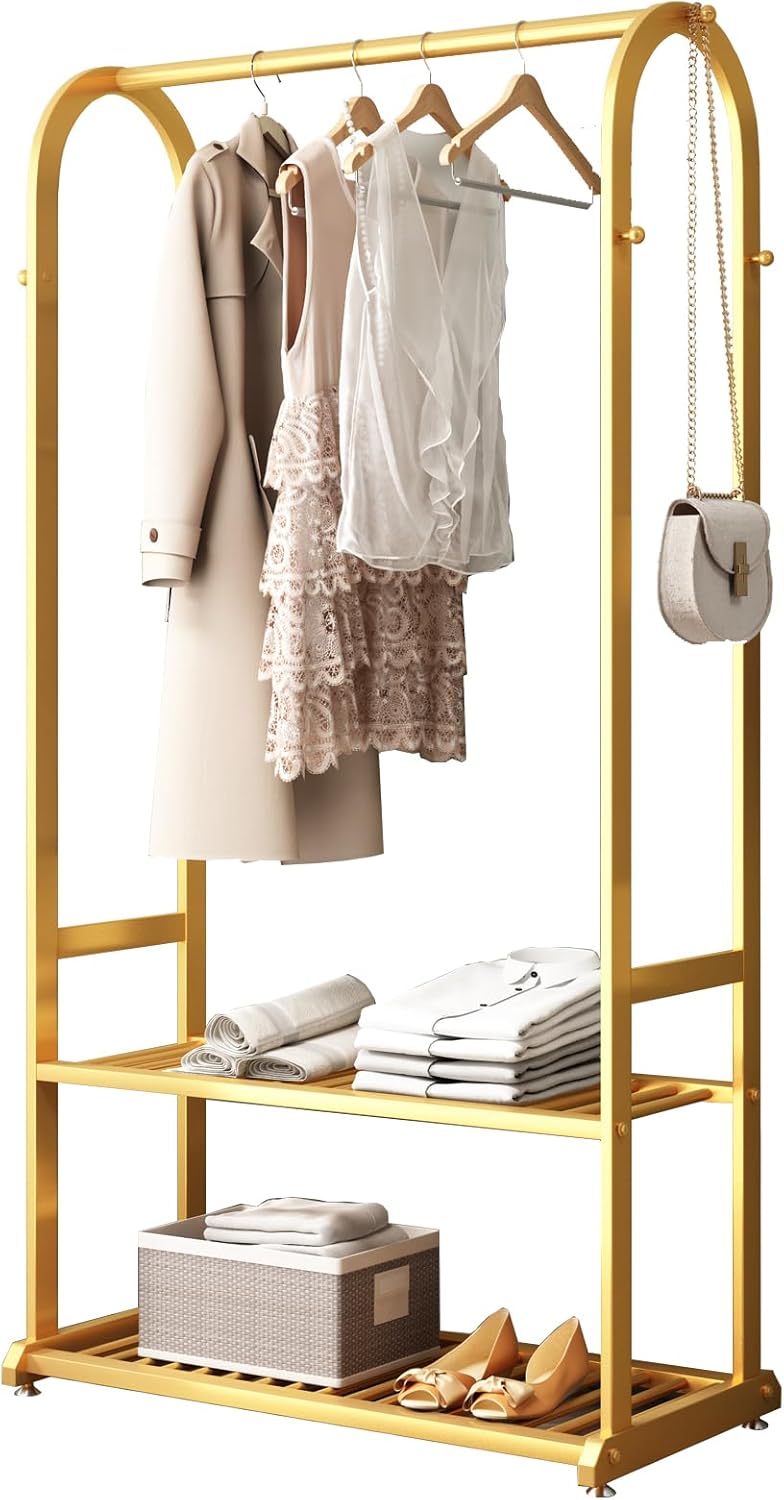 Gold metal clothing rack with shelves holding clothes and shoes