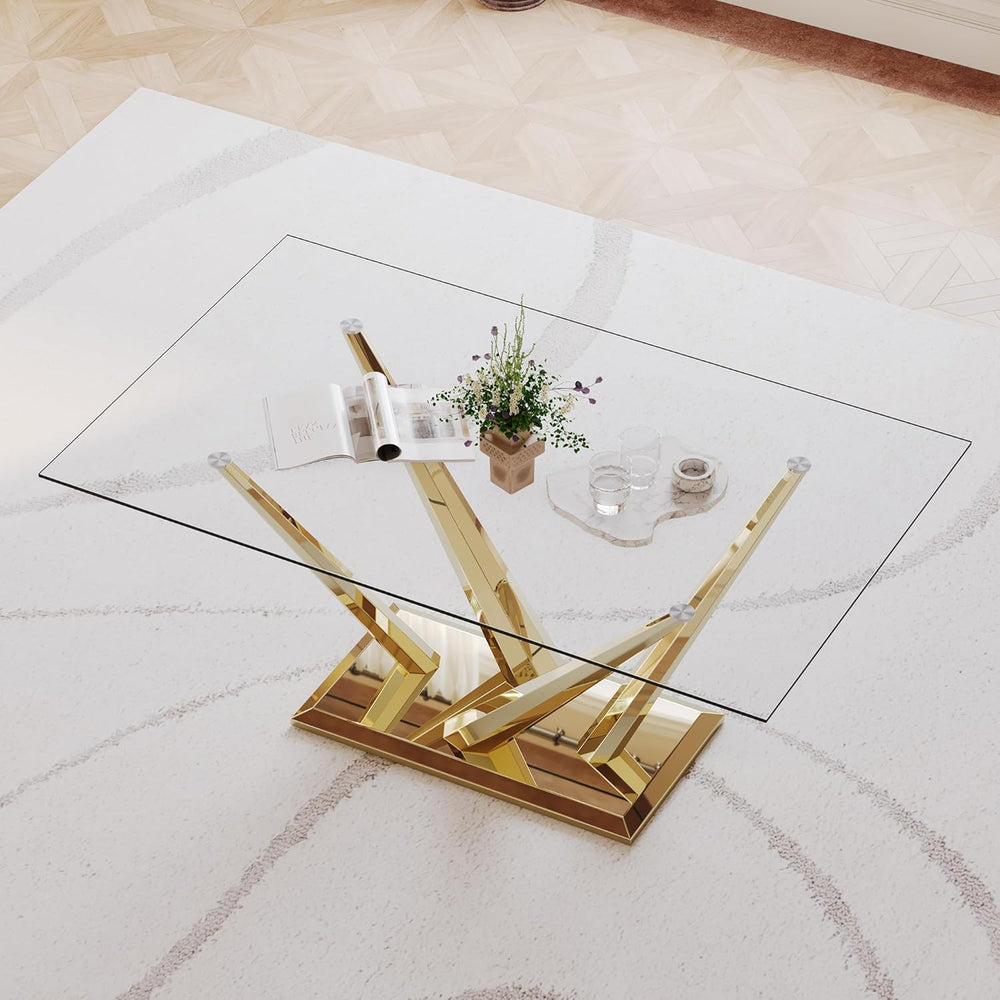 Glass coffee table with gold metal base on a light-colored floor
