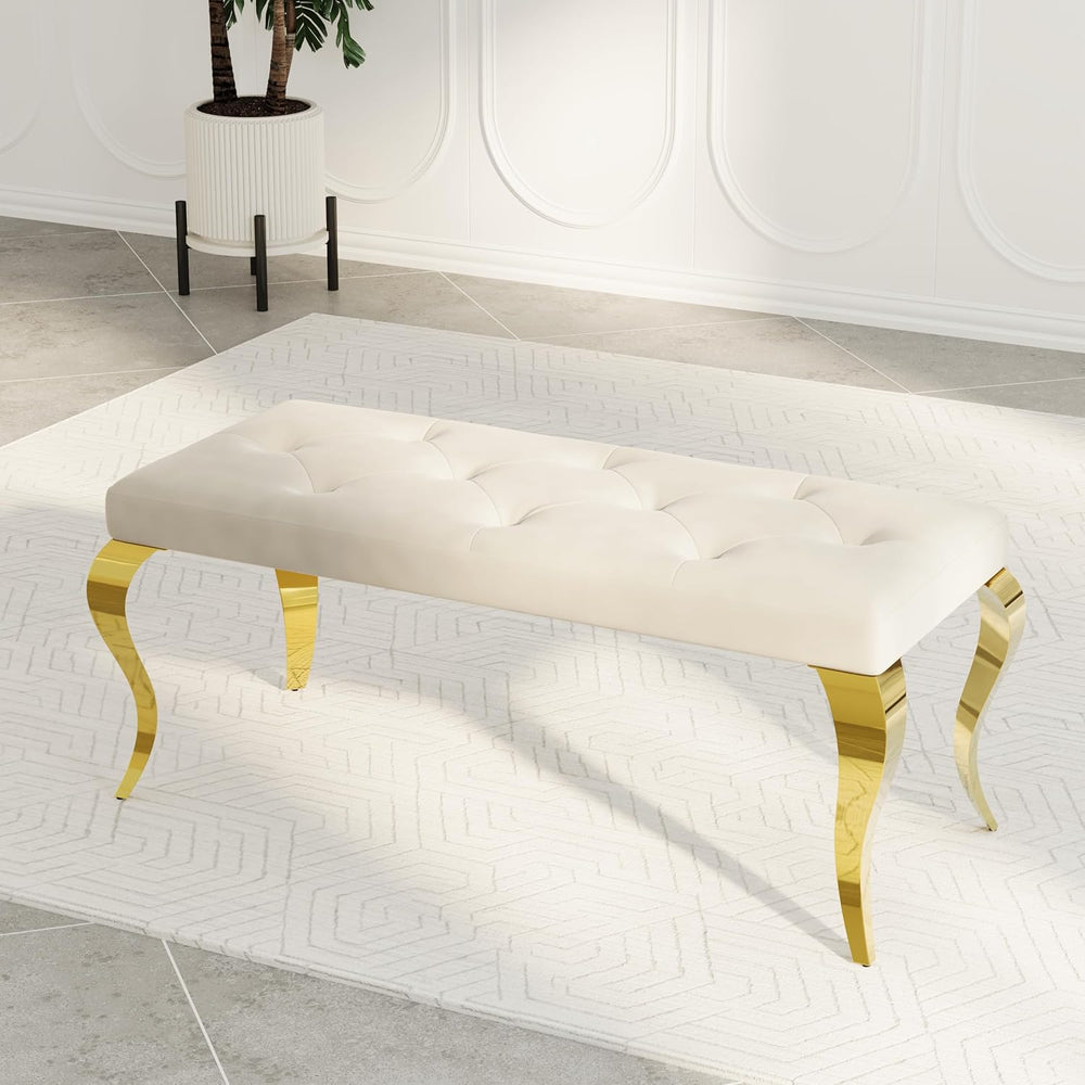 Beige tufted bench with gold legs in a modern interior setting