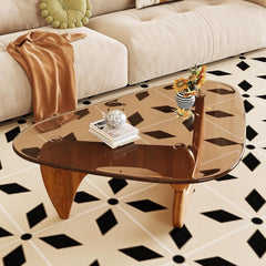 Glass coffee table with decorative items on a patterned floor