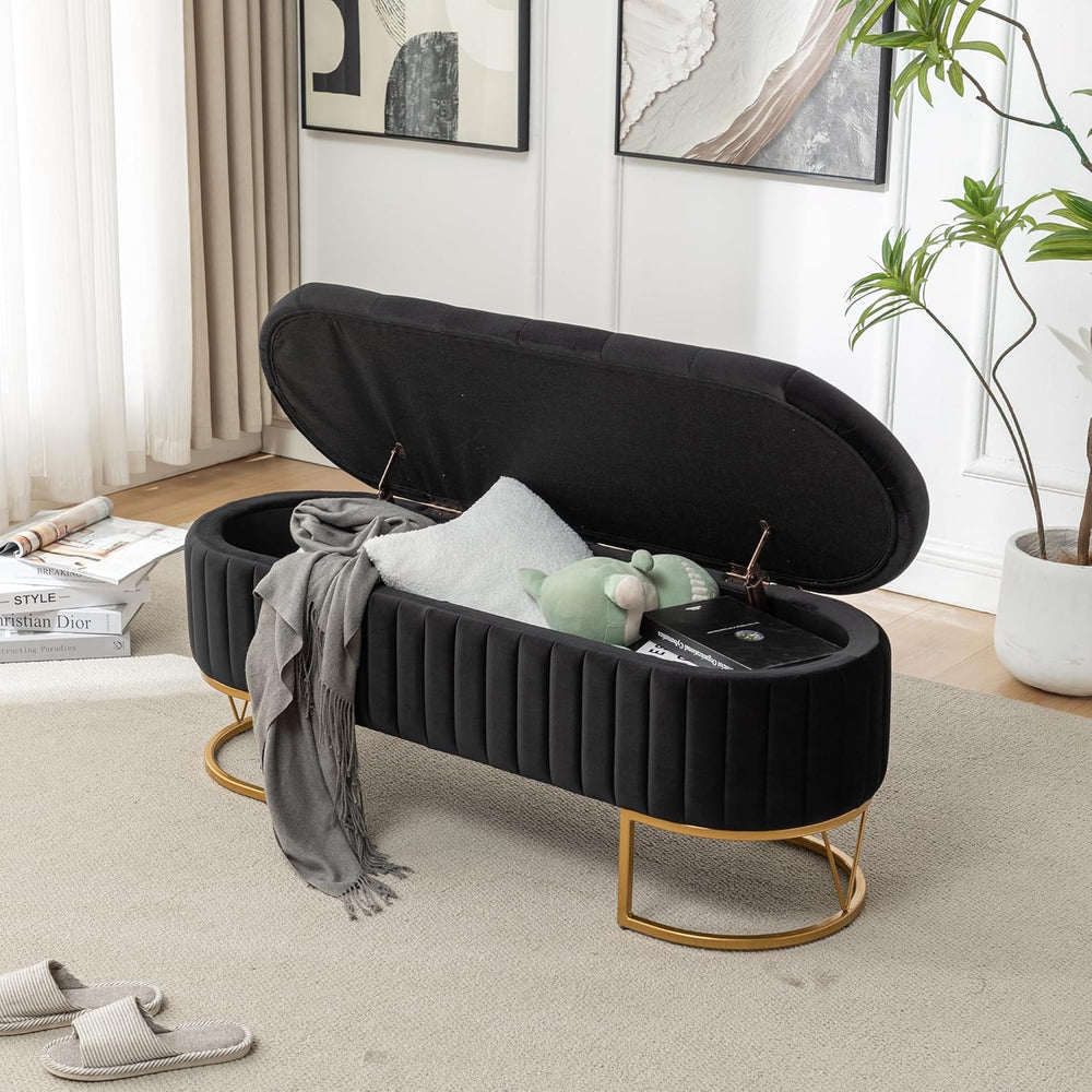 Black storage bench with gold legs in a living room setting