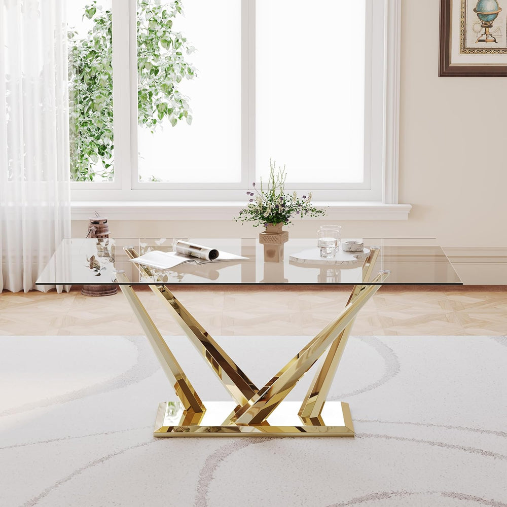 Modern glass coffee table with gold metal legs in a living room setting.