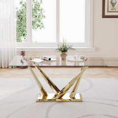 Modern glass coffee table with gold metal legs in a living room setting.
