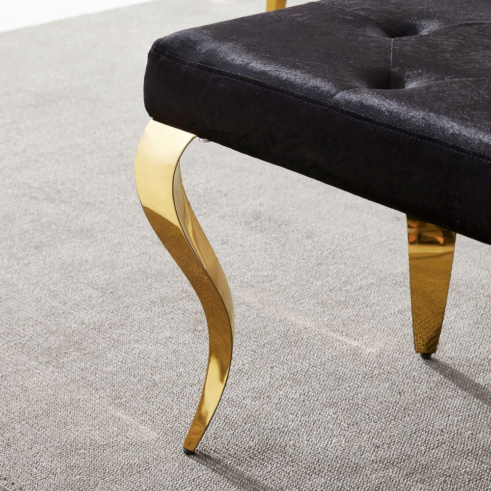 Black upholstered bench with gold legs on a light gray carpet