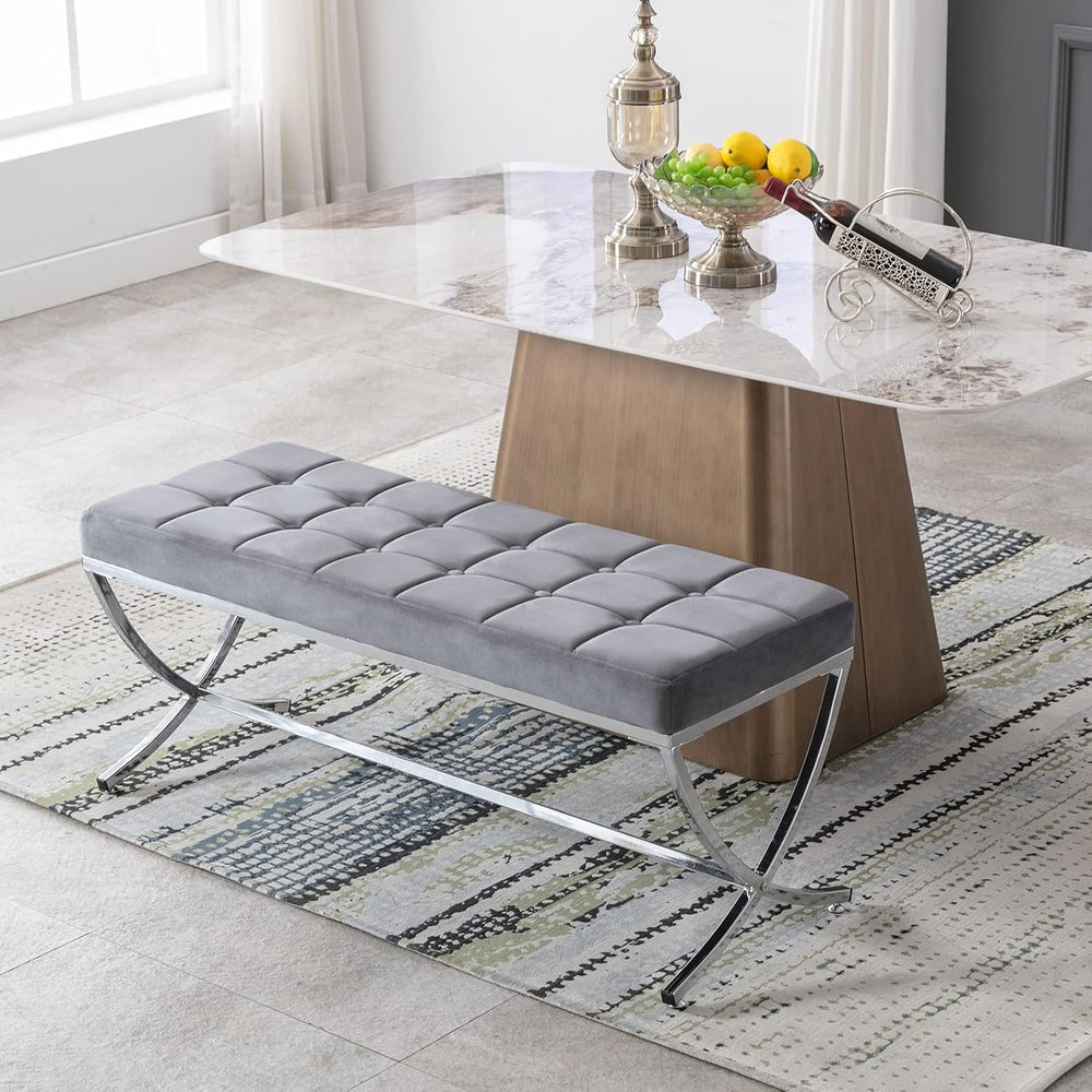 Gray upholstered bench in front of a marble table in a modern living room.