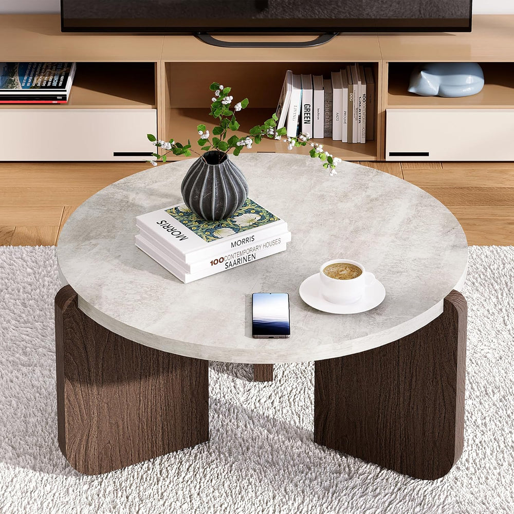 Round coffee table with decorative items in a living room setting