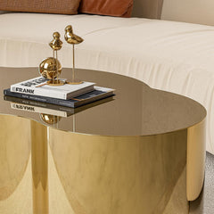 Gold coffee table with decorative books and bird figurines in a living room setting.