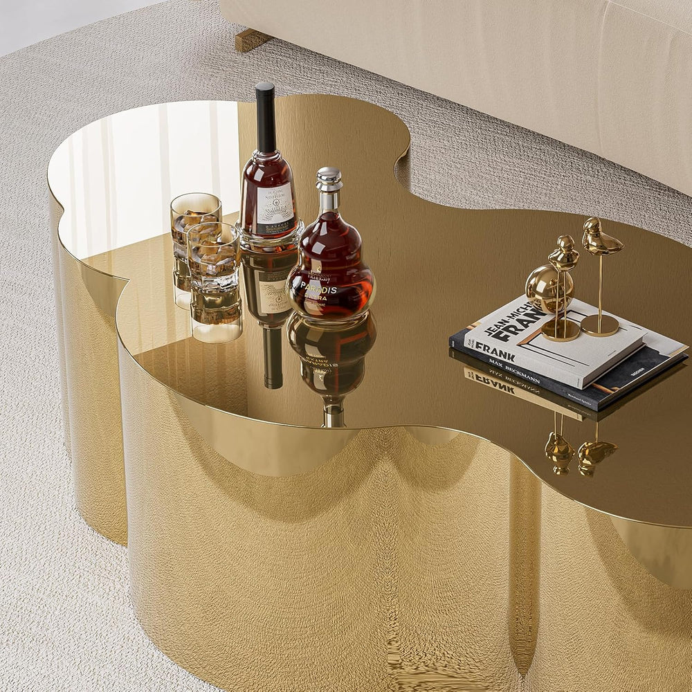Gold side table with bottles, glasses, and books on a white background