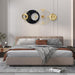 Modern bedroom with a bed and decorative wall clocks.