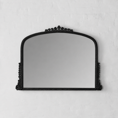 Black decorative mirror on a white wall