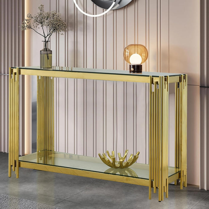 Gold console table with glass top and shelf against a striped wall.