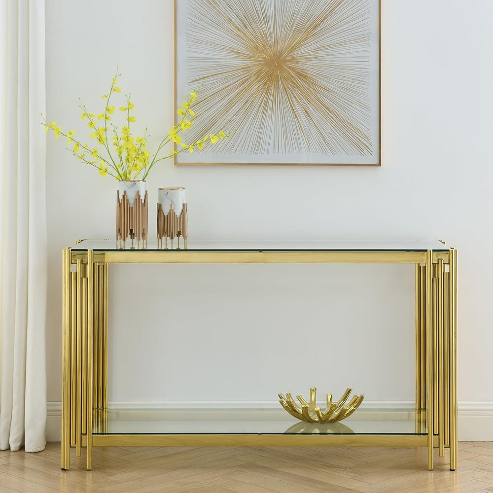 Gold console table with glass top in a room with a abstract painting on the wall.