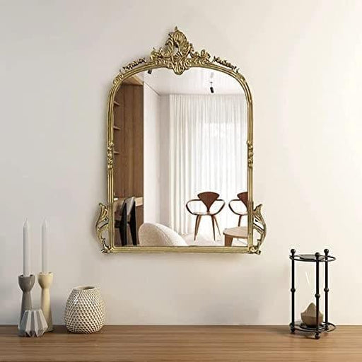 Decorative gold mirror on a wall with a room reflection