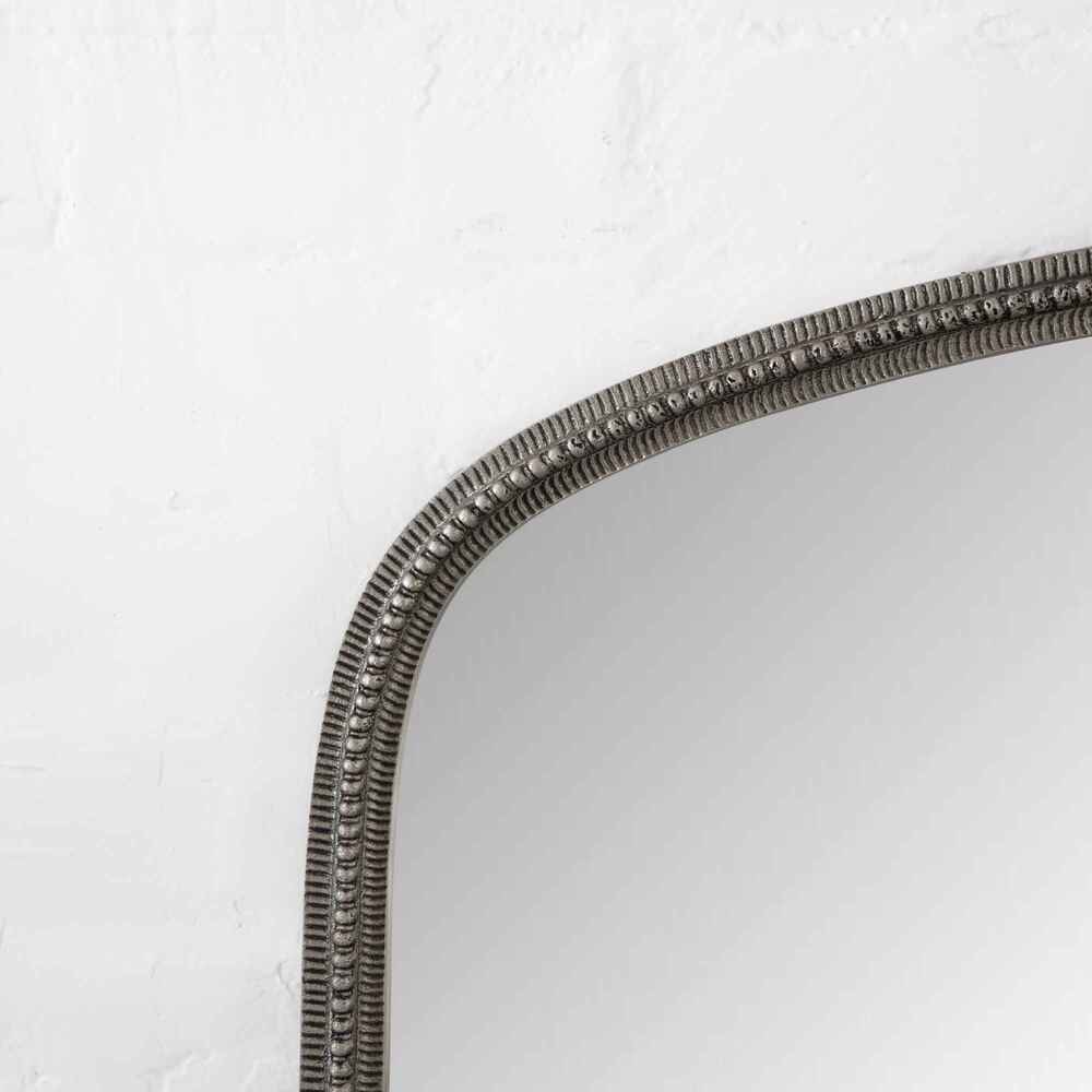 Decorative mirror with a textured frame on a white background