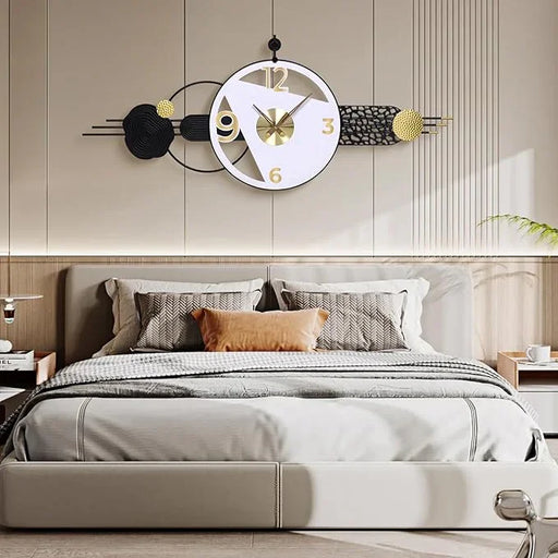 Decorative wall clock above a bed in a bedroom setting