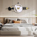 Decorative wall clock above a bed in a bedroom setting