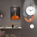 Decorative wall clock with abstract design on a gray wall above a desk.