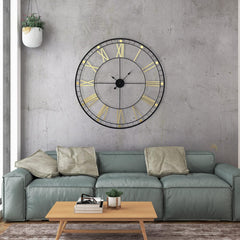 Living room with a large wall clock, gray sofa, and wooden coffee table.