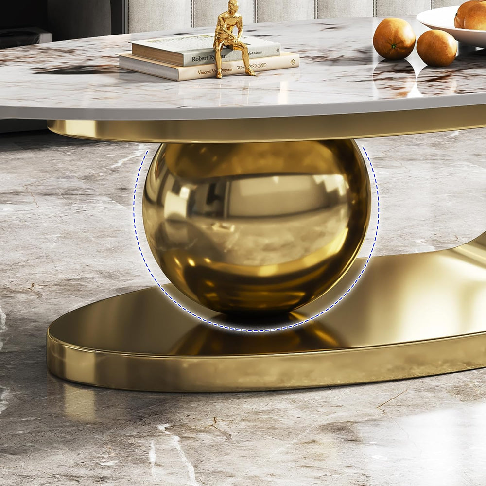 Marble table with gold base and decor items on a marble floor.