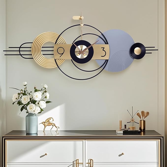 Modern wall clock with decorative elements on a light gray wall above a console table.