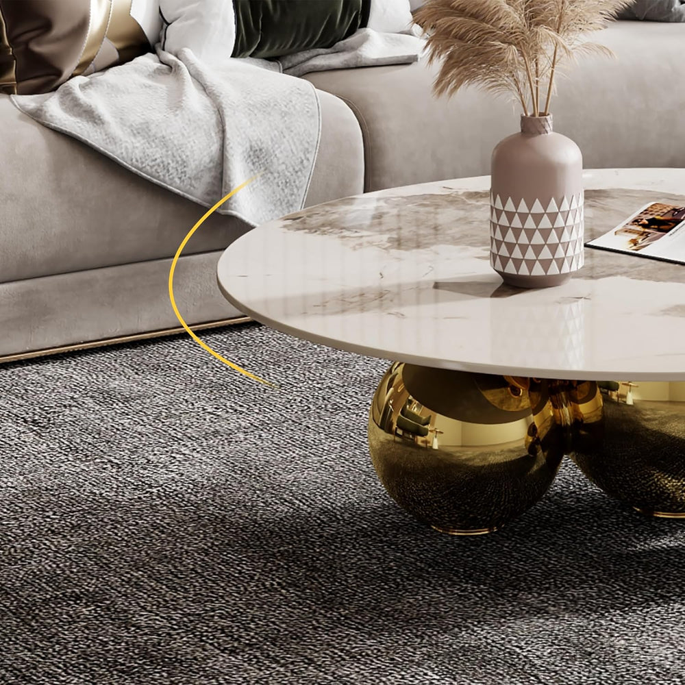 Modern living room with a coffee table featuring gold legs and a decorative vase.