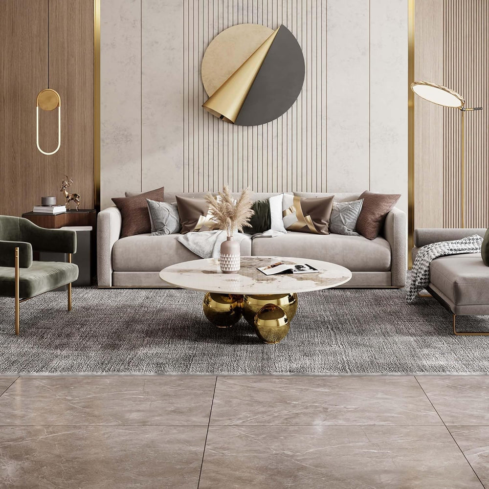 Modern living room with a gray sofa, gold coffee table, and decorative wall art.